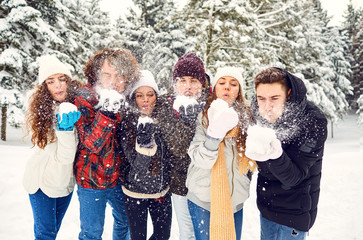 Friends throw fun snow in the park in winter