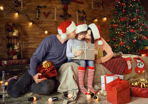 Parents give daughter a gift while at Christmas.