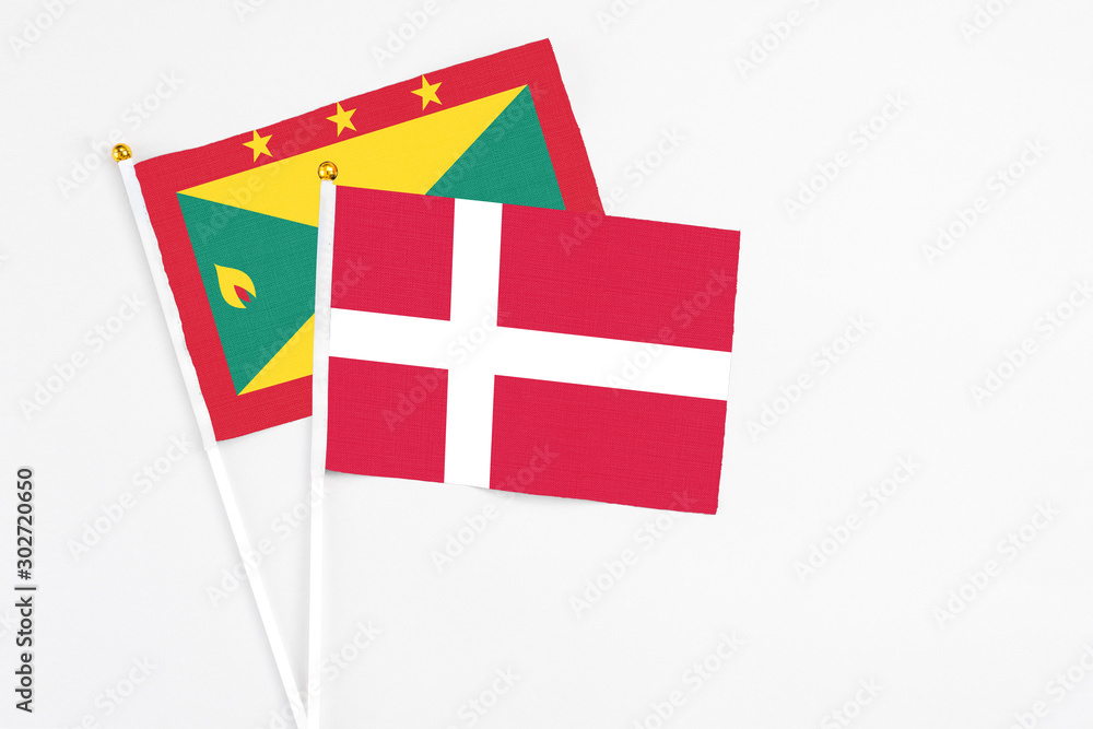 Denmark and Grenada stick flags on white background. High quality fabric, miniature national flag. Peaceful global concept.White floor for copy space.