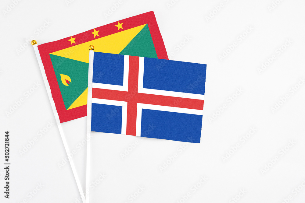 Iceland and Grenada stick flags on white background. High quality fabric, miniature national flag. Peaceful global concept.White floor for copy space.