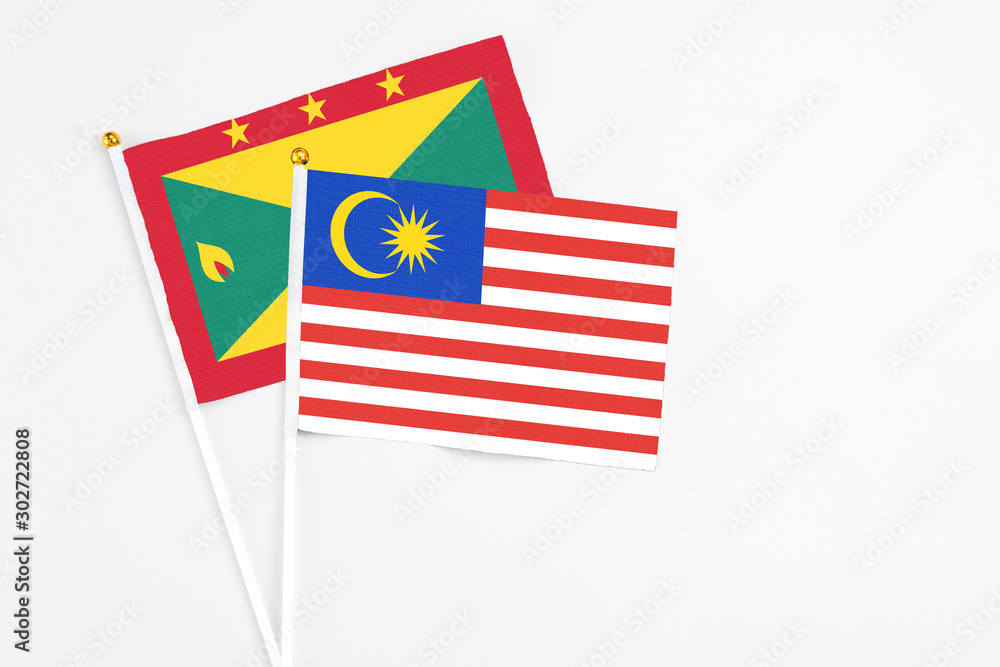 Malaysia and Grenada stick flags on white background. High quality fabric, miniature national flag. Peaceful global concept.White floor for copy space. Malaysia and Grenada stick flags on white background. High quality fabric, miniature national flag. Peaceful global concept.White floor for copy space.