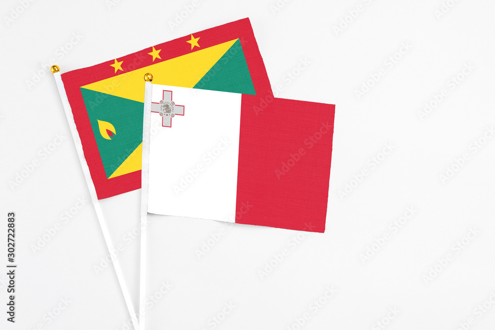 Malta and Grenada stick flags on white background. High quality fabric, miniature national flag. Peaceful global concept.White floor for copy space. Malta and Grenada stick flags on white background. High quality fabric, miniature national flag. Peaceful global concept.White floor for copy space.