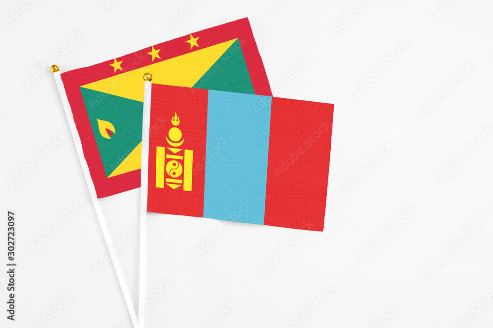 Fototapeta premium Mongolia and Grenada stick flags on white background. High quality fabric, miniature national flag. Peaceful global concept.White floor for copy space.