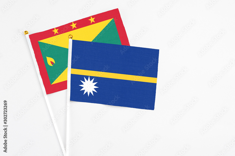 Nauru and Grenada stick flags on white background. High quality fabric, miniature national flag. Peaceful global concept.White floor for copy space. Nauru and Grenada stick flags on white background. High quality fabric, miniature national flag. Peaceful global concept.White floor for copy space.