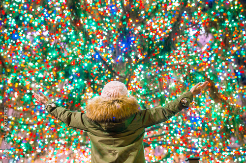 Tableau sur toile Happy girl on the background of the Rockefeller Christmas tree in New York