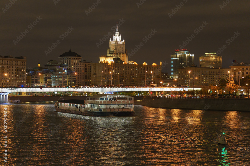 Moscow downtown architecture in night. Ministry of Foreign Affairs (MFA) in distance. Moskva river is full of city lights reflections.