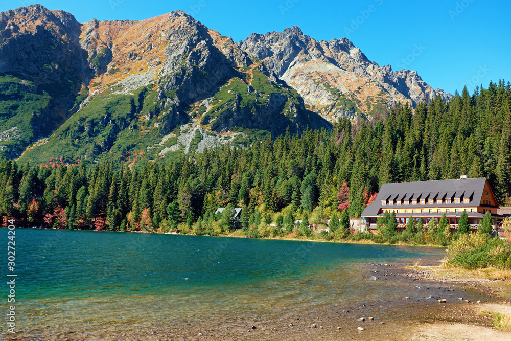 The beautiful autumn Poprad lake with mountains and colorful forests in High Tatras National Park, Slovakia