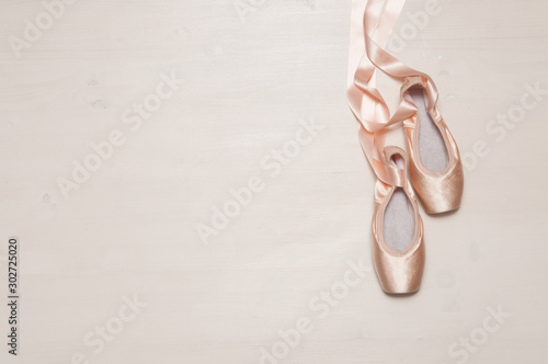 Ballet pointe shoes isolated on wooden background