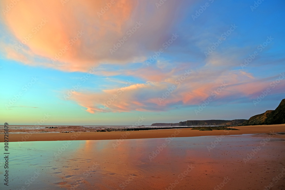 Beautiful cloudscape at Praia Vale Figueiras in Portugal at sunset