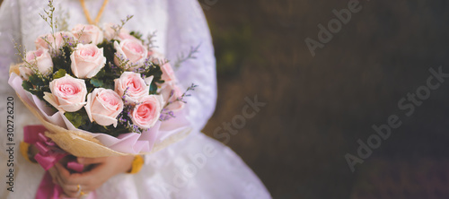 A bouquet of roses in the bride's hand