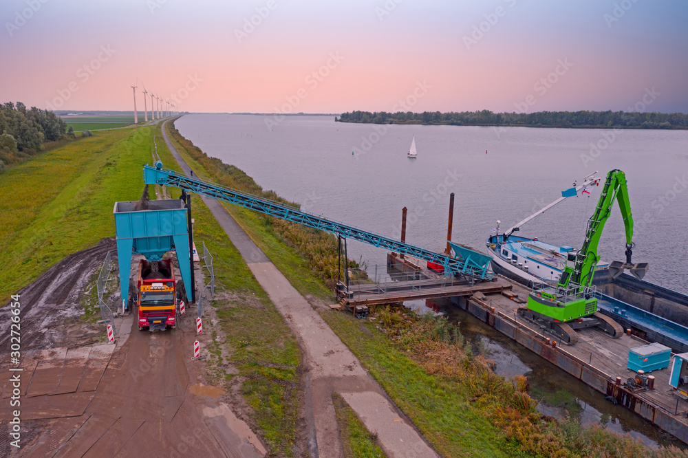 Fototapeta premium Aerial from freighter unloading sand in the countryside from the Netherlands