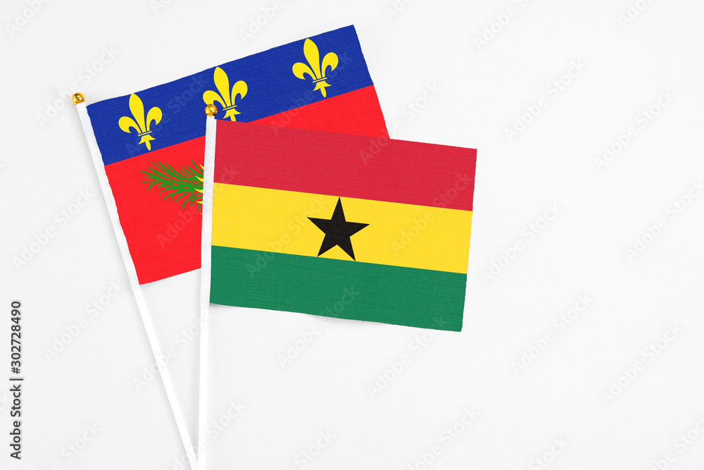Ghana and Guadeloupe stick flags on white background. High quality fabric, miniature national flag. Peaceful global concept.White floor for copy space. Ghana and Guadeloupe stick flags on white background. High quality fabric, miniature national flag. Peaceful global concept.White floor for copy space.