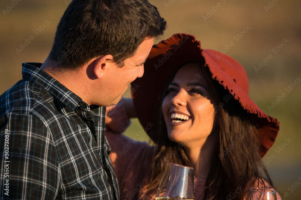 Happy romantic couple laughing and enjoying a glass of wine Happy romantic couple laughing and enjoying a glass of wine