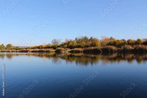 Lake shoreline reflecting symmetric in the water