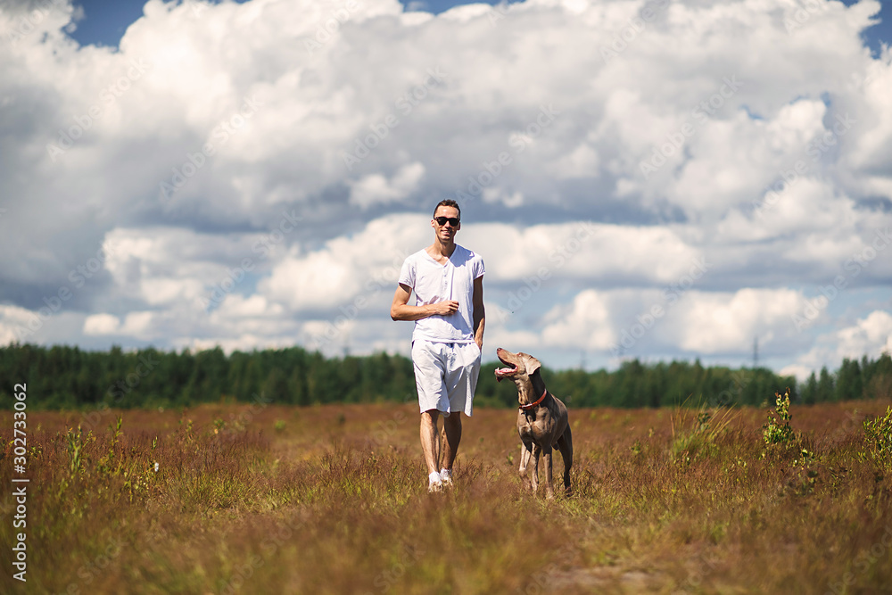 Man walking with dog in rural field Man walking with dog in rural field