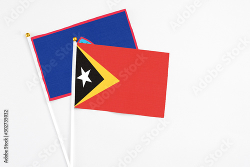Free Download East Timor and Guam stick flags on white background. High quality fabric, miniature national flag. Peaceful global concept.White floor for copy space. - GFXLoad