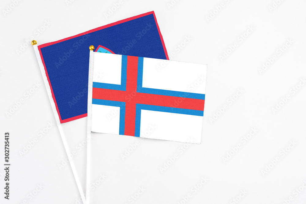 Faroe Islands and Guam stick flags on white background. High quality fabric, miniature national flag. Peaceful global concept.White floor for copy space. Faroe Islands and Guam stick flags on white background. High quality fabric, miniature national flag. Peaceful global concept.White floor for copy space.