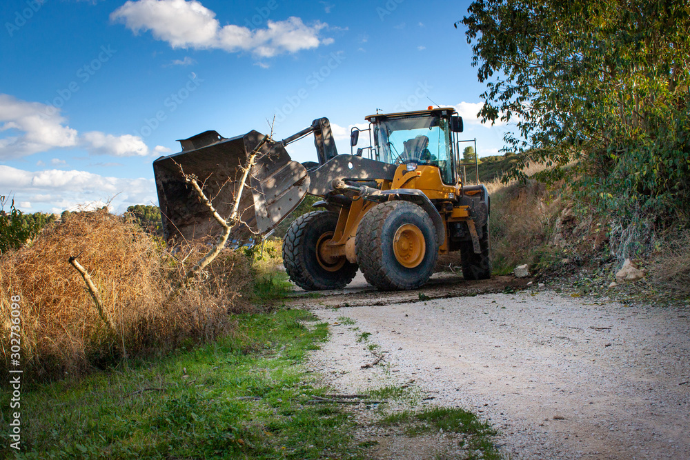 .Excavator shovel clearing dirt and tree roads from a natural disaster .Excavator shovel clearing dirt and tree roads from a natural disaster