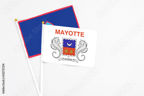 Mayotte and Guam stick flags on white background. High quality fabric, miniature national flag. Peaceful global concept.White floor for copy space.