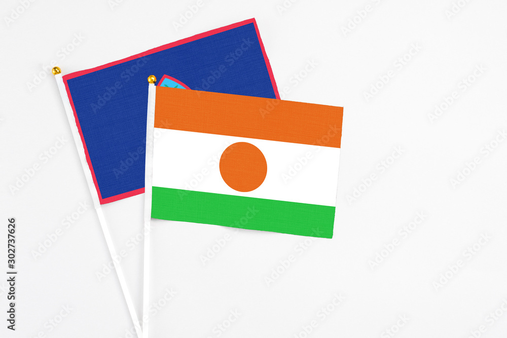 Niger and Guam stick flags on white background. High quality fabric, miniature national flag. Peaceful global concept.White floor for copy space. Niger and Guam stick flags on white background. High quality fabric, miniature national flag. Peaceful global concept.White floor for copy space.