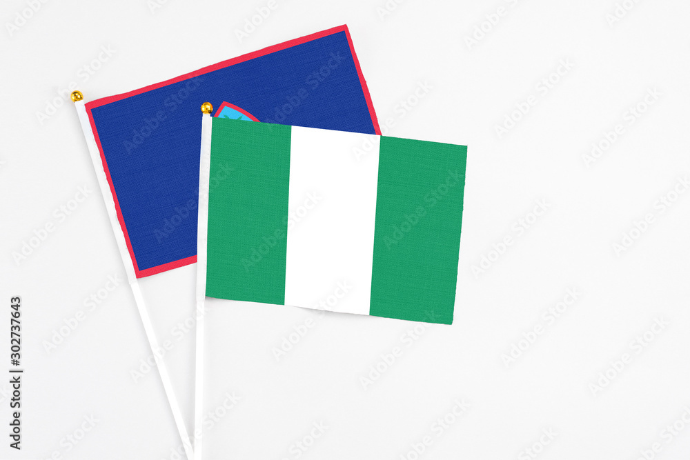 Nigeria and Guam stick flags on white background. High quality fabric, miniature national flag. Peaceful global concept.White floor for copy space. Nigeria and Guam stick flags on white background. High quality fabric, miniature national flag. Peaceful global concept.White floor for copy space.
