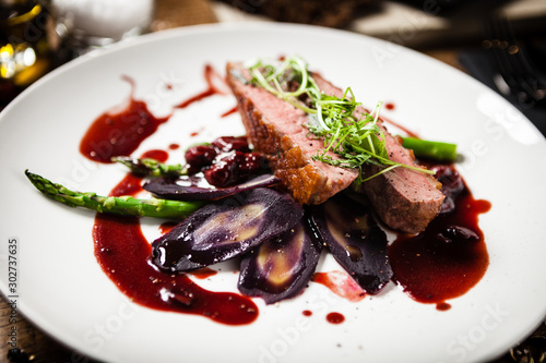 Duck breast served on a plate in restaurant photo