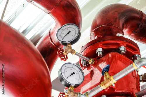 Pressure gauges on a red tubes. Industrial fire extinguishing system manometers. photo