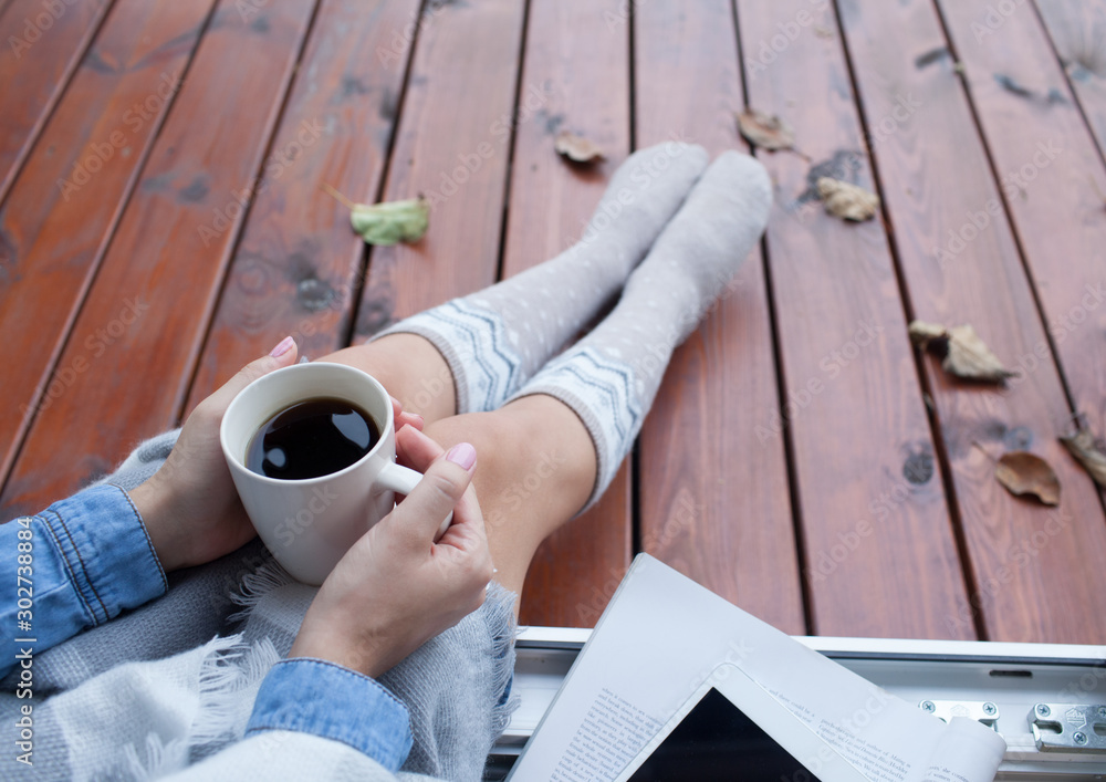 Φωτογραφία Woman with cup of coffee sitting relaxing home in the window, she's covered in a blanket