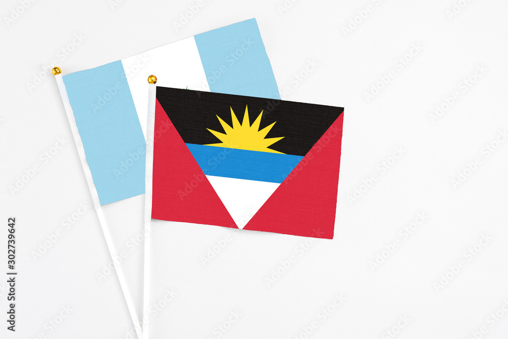 Obraz premium Antigua and Barbuda and Guatemala stick flags on white background. High quality fabric, miniature national flag. Peaceful global concept.White floor for copy space.