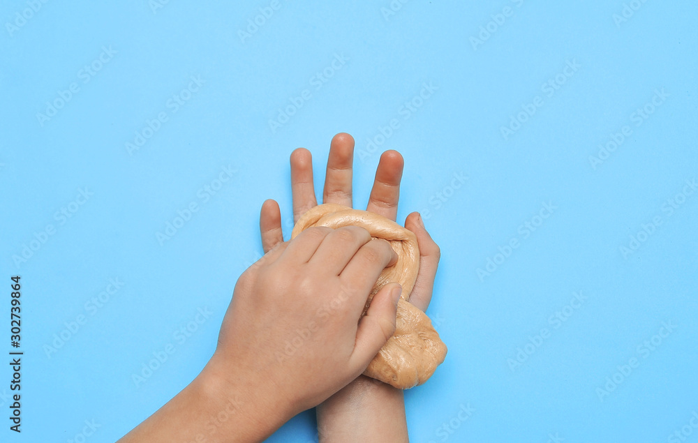 Child hands with slime on blue background. Child hands with slime on blue background.