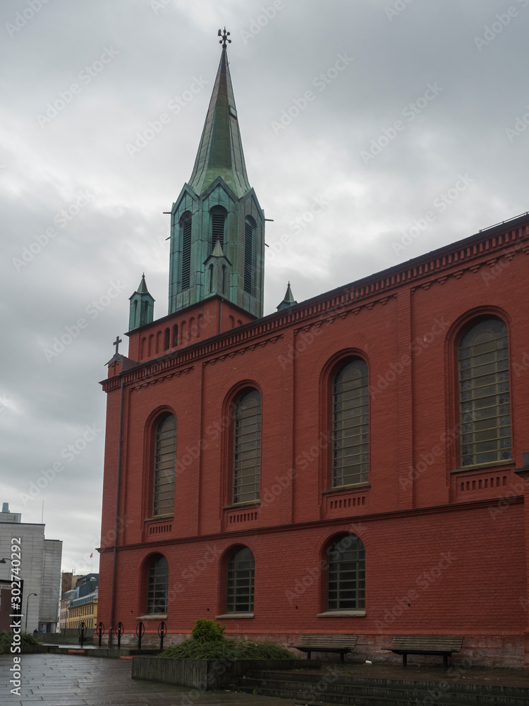 STAVANGER, NORWAY, SEPTEMBER 9, 2019 :View on St. Peter Church or St. Petri Kirke is red brick building and was built in 1866, Stavanger city center. Rainy moody day. Travel and architecture