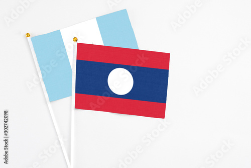 Free Download Laos and Guatemala stick flags on white background. High quality fabric, miniature national flag. Peaceful global concept.White floor for copy space. - GFXLoad