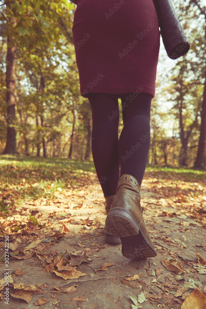 Women's legs standing in autumn leaves. Women's legs standing in autumn leaves.