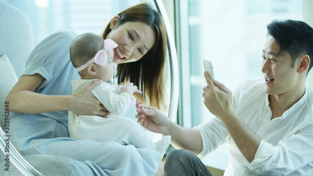Chinese Asian dad taking photos wife baby smartphone Chinese Asian dad taking photos wife baby smartphone