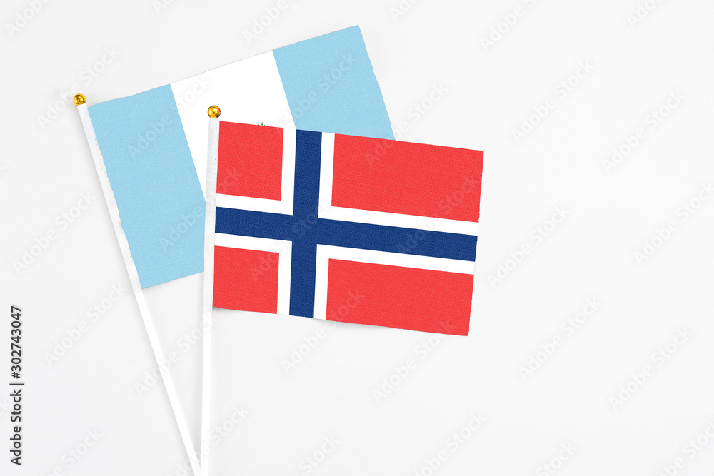 Norway and Guatemala stick flags on white background. High quality fabric, miniature national flag. Peaceful global concept.White floor for copy space.