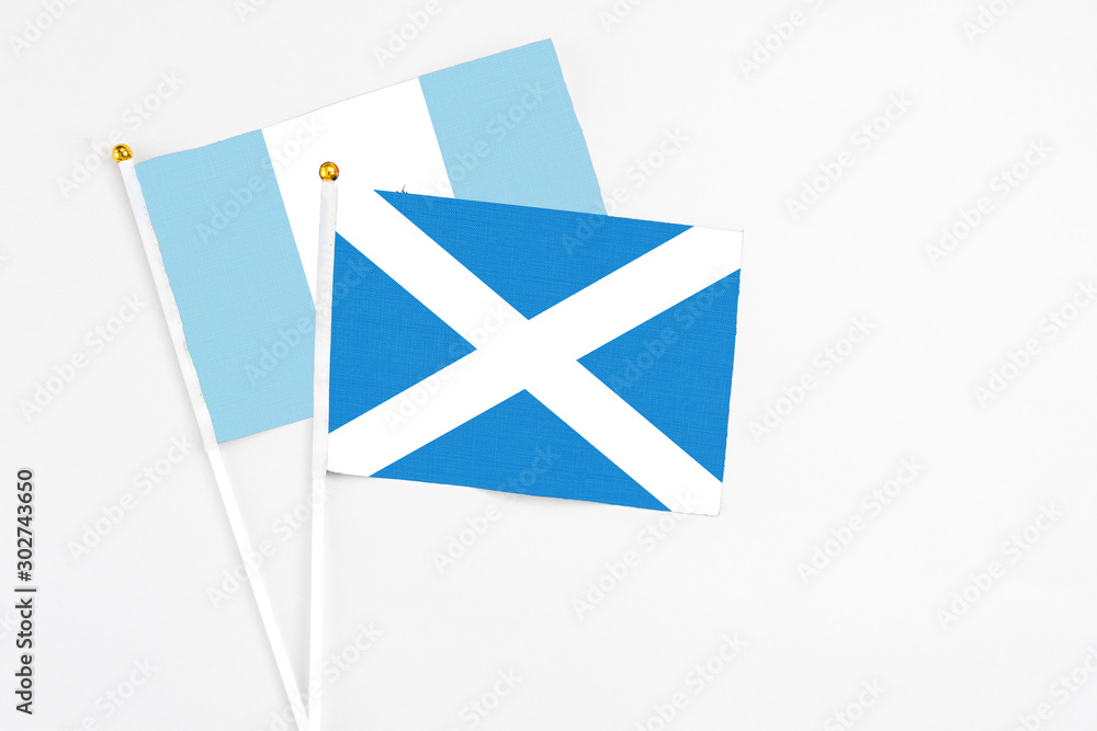 Scotland and Guatemala stick flags on white background. High quality fabric, miniature national flag. Peaceful global concept.White floor for copy space. Scotland and Guatemala stick flags on white background. High quality fabric, miniature national flag. Peaceful global concept.White floor for copy space.