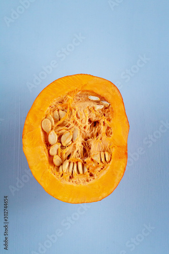 Half of fresh pumpkin isolated on blue background with space for  text