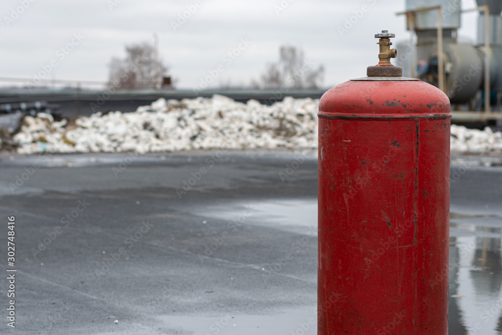 The roof of the factory. There is a big red propane gas bottle. In the background pieces of building polystyrene The roof of the factory. There is a big red propane gas bottle. In the background pieces of building polystyrene