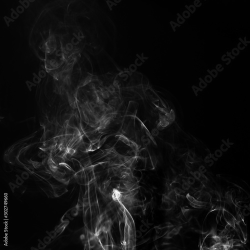 Gray smoke on a black background. Realistic incense smoke captured with a flash.
