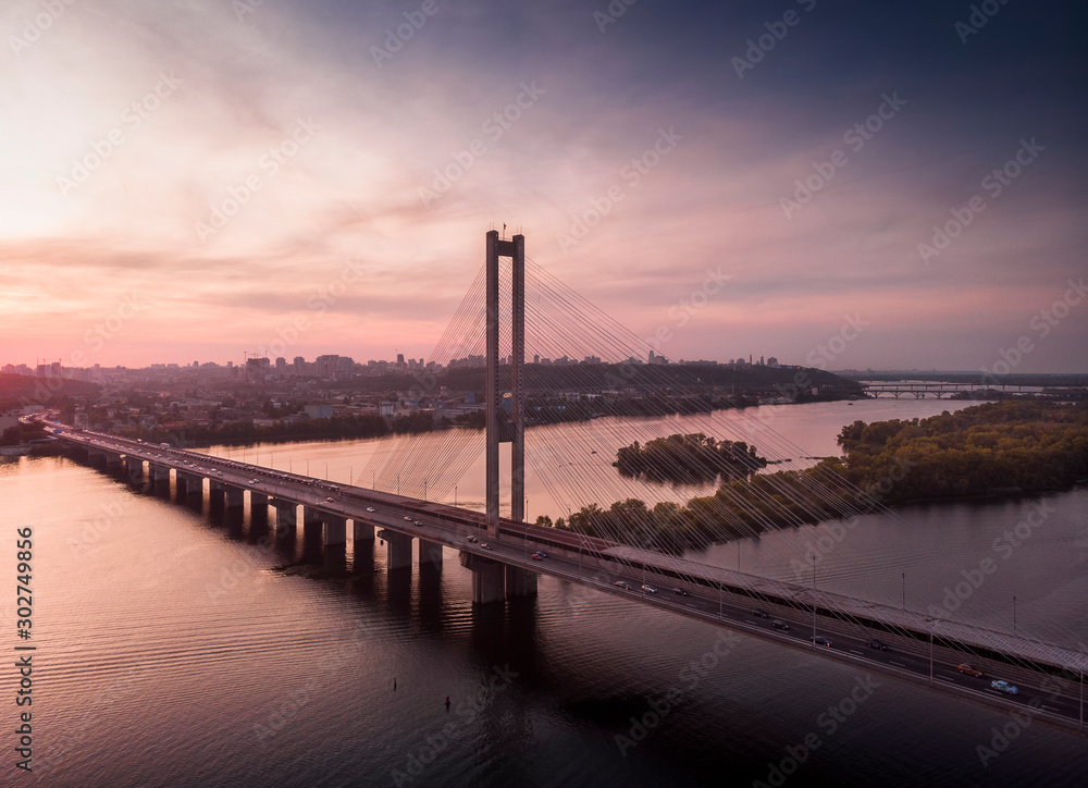 Aerial view of Pivdenny Bridge in the purple sunset; background of city life Aerial view of Pivdenny Bridge in the purple sunset; background of city life