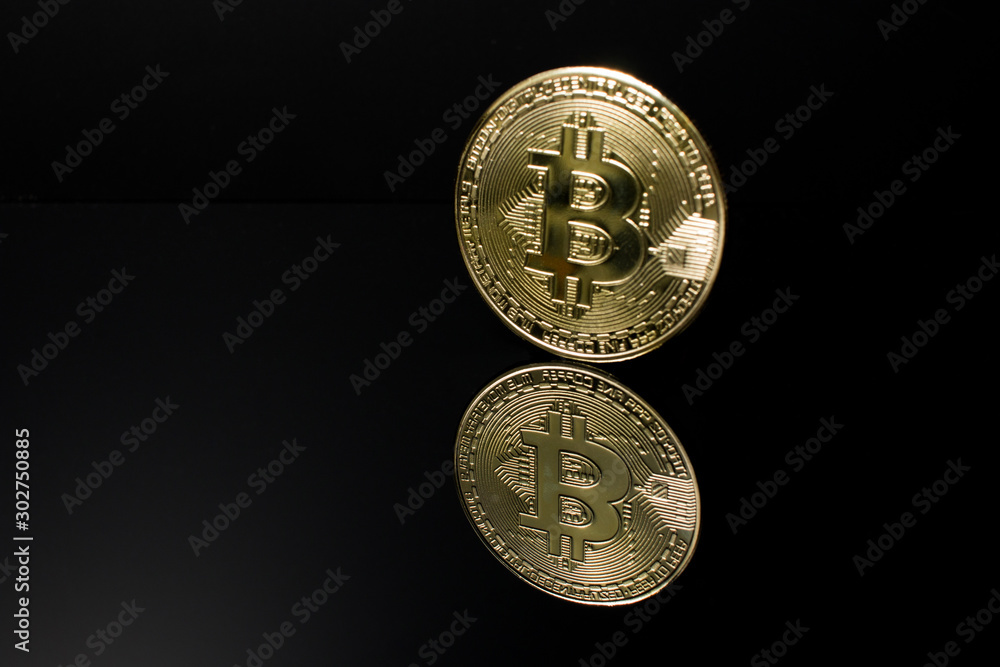 Closeup of a golden bitcoin coin with reflection and a dark black background. crypto currency. Closeup of a golden bitcoin coin with reflection and a dark black background. crypto currency.