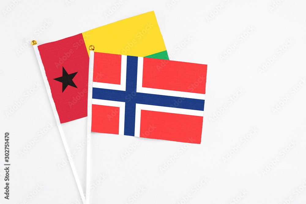 Bouvet Islands and Guinea Bissau stick flags on white background. High quality fabric, miniature national flag. Peaceful global concept.White floor for copy space.