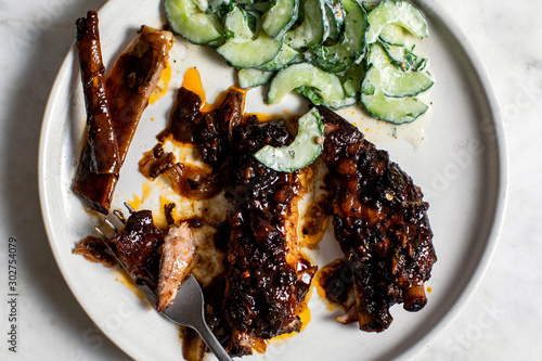 Overhead view of sweet and spicy ribs with cucumber†raita