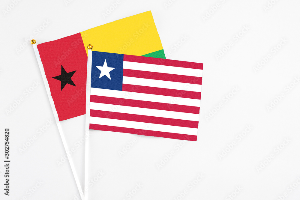 Liberia and Guinea Bissau stick flags on white background. High quality fabric, miniature national flag. Peaceful global concept.White floor for copy space. Liberia and Guinea Bissau stick flags on white background. High quality fabric, miniature national flag. Peaceful global concept.White floor for copy space.