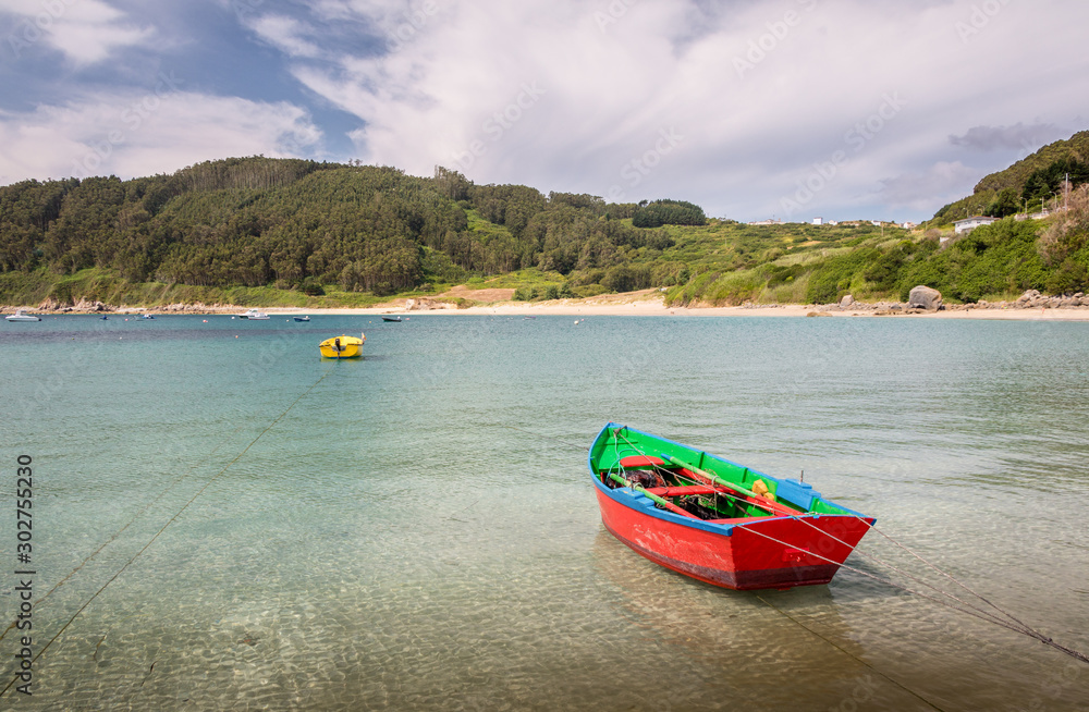 Barcas de color rojo y amarillo amarradas en un puerto natural en el oceano Atlántico, en Galicia, España. Barcas de color rojo y amarillo amarradas en un puerto natural en el oceano Atlántico, en Galicia, España.