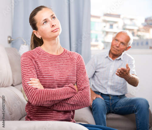 Elderly father and adult daughter quarrelling in domestic interior