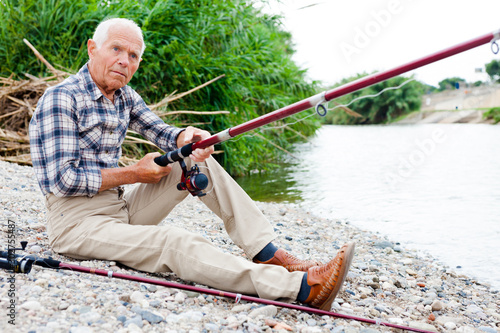 Aged man fishing at lakeside