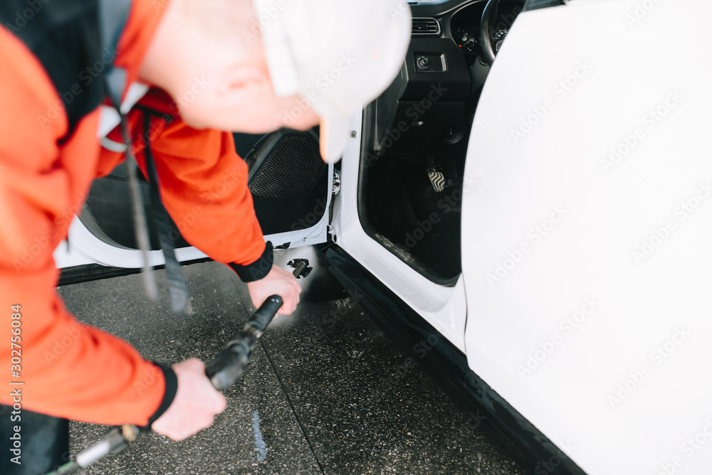 Obraz premium Male hands cleans car interior on carwash station
