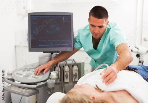 doctor conducting ultrasound examination of patient's thyroid lying