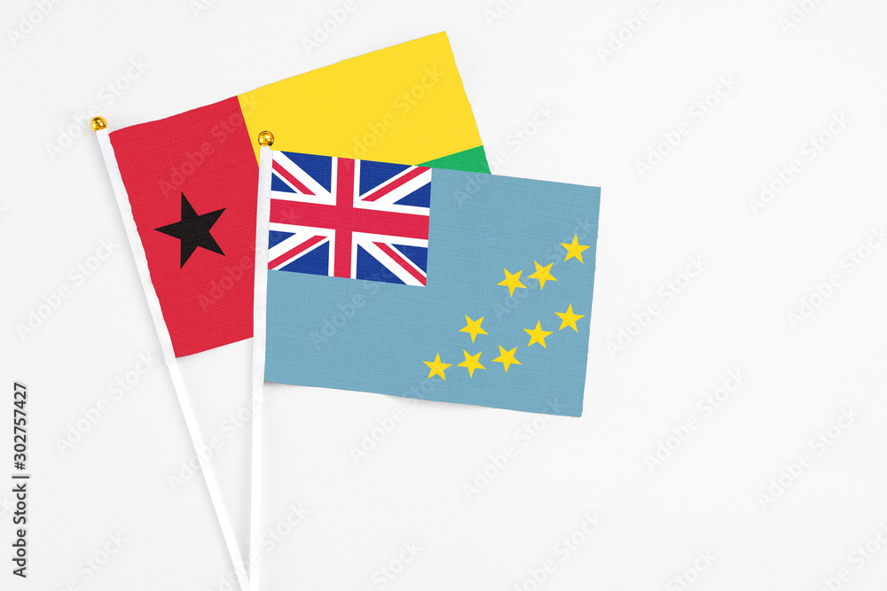 Tuvalu and Guinea Bissau stick flags on white background. High quality fabric, miniature national flag. Peaceful global concept.White floor for copy space. Tuvalu and Guinea Bissau stick flags on white background. High quality fabric, miniature national flag. Peaceful global concept.White floor for copy space.